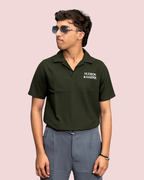 Person wearing a green polo shirt with 'Hudson & Harper' logo on a pink background